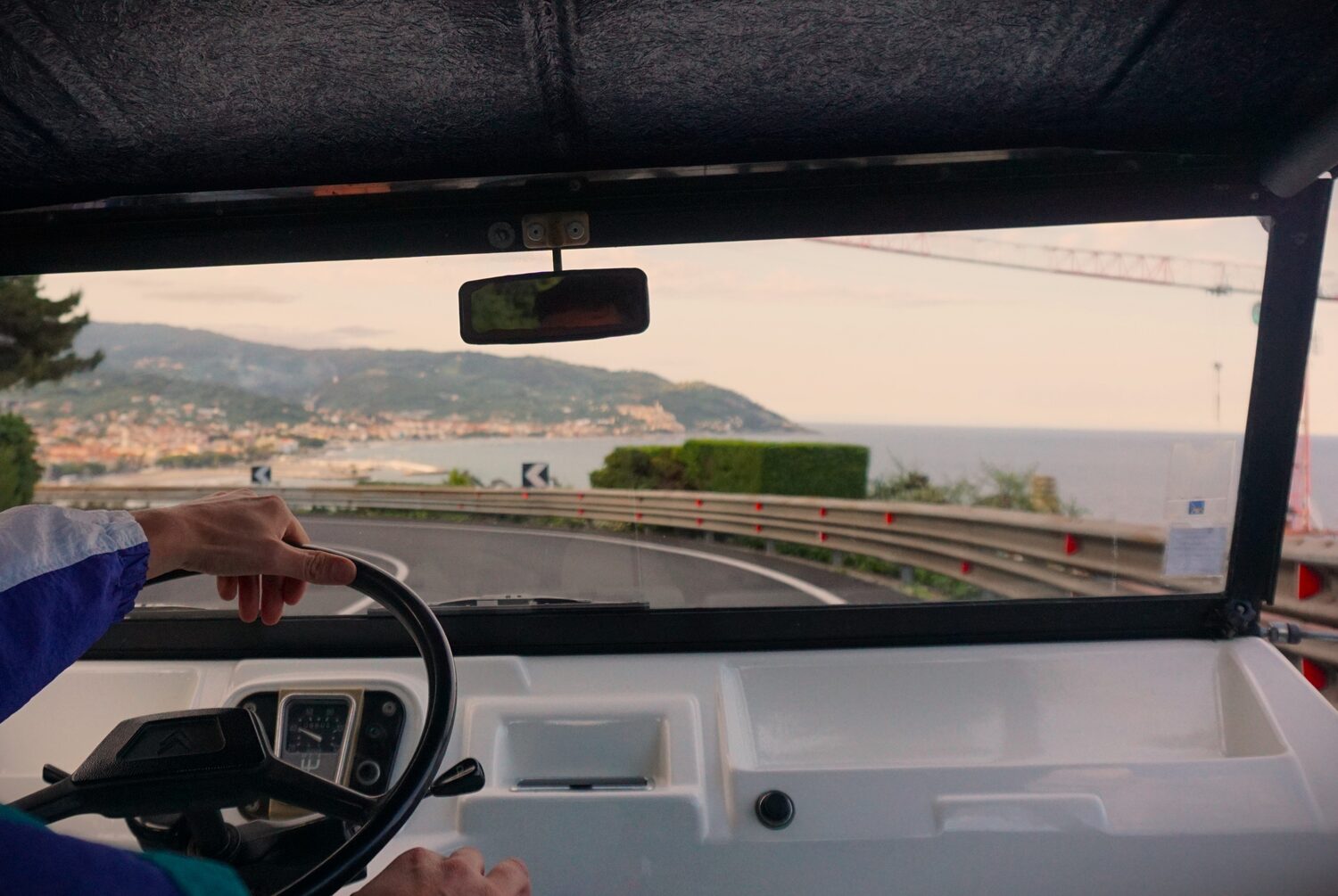Guests riding open-top in a classic car along the coast