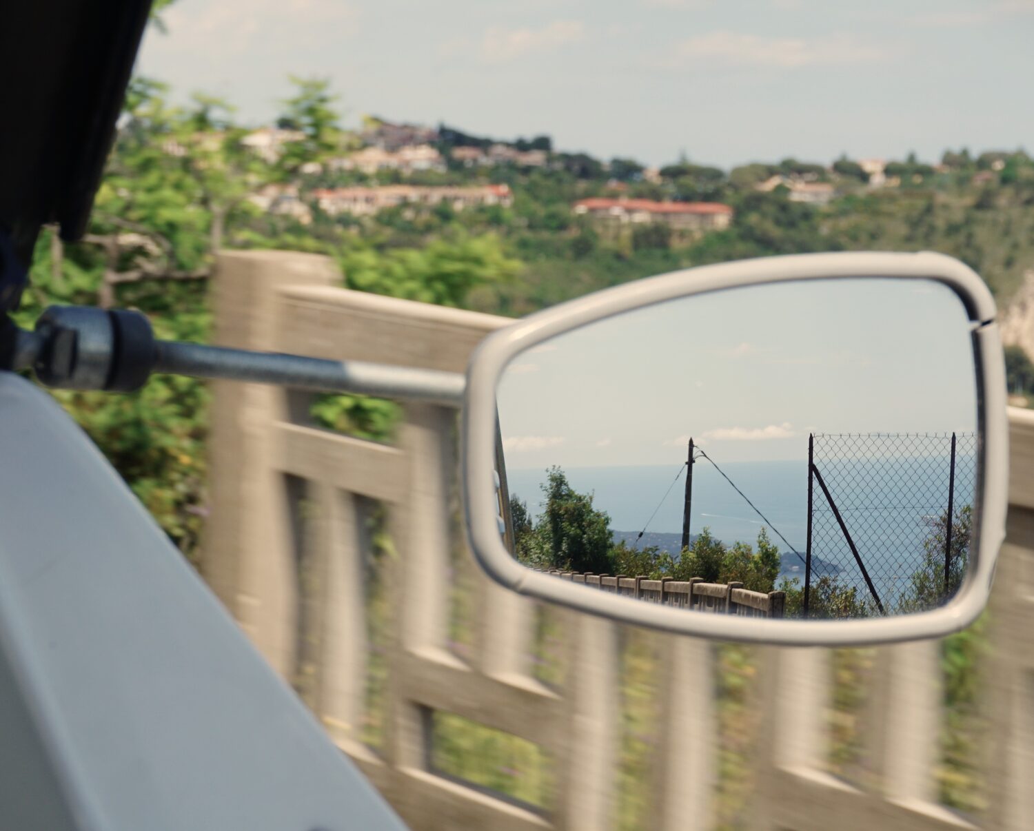 The coastline reflected in a classic car wing mirror